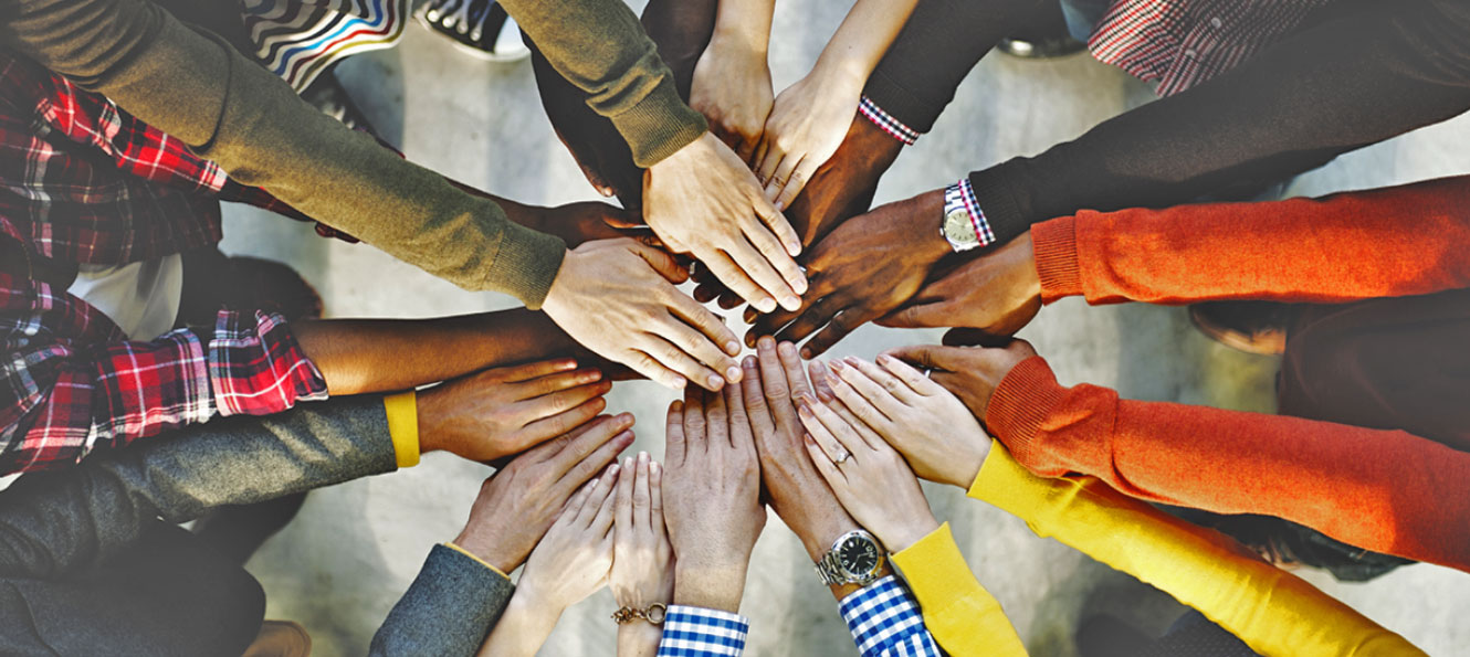 closeup of a group of hands gathered together in a circle