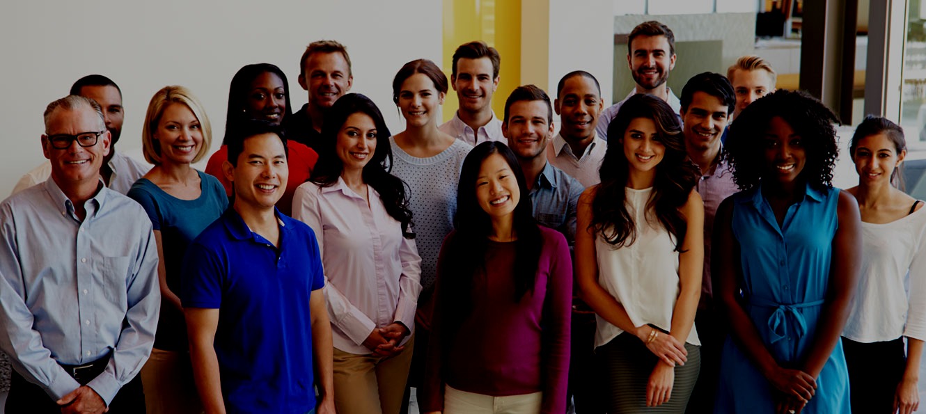 group of smiling employees standing in the lobby as part of a group shot together