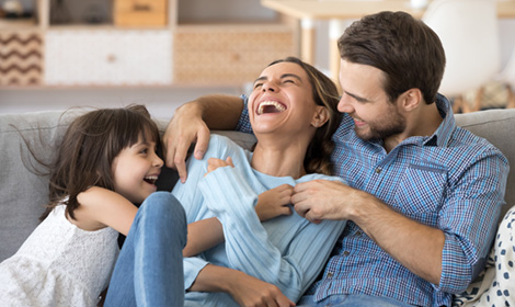 family of three smiling and enjoying their time together