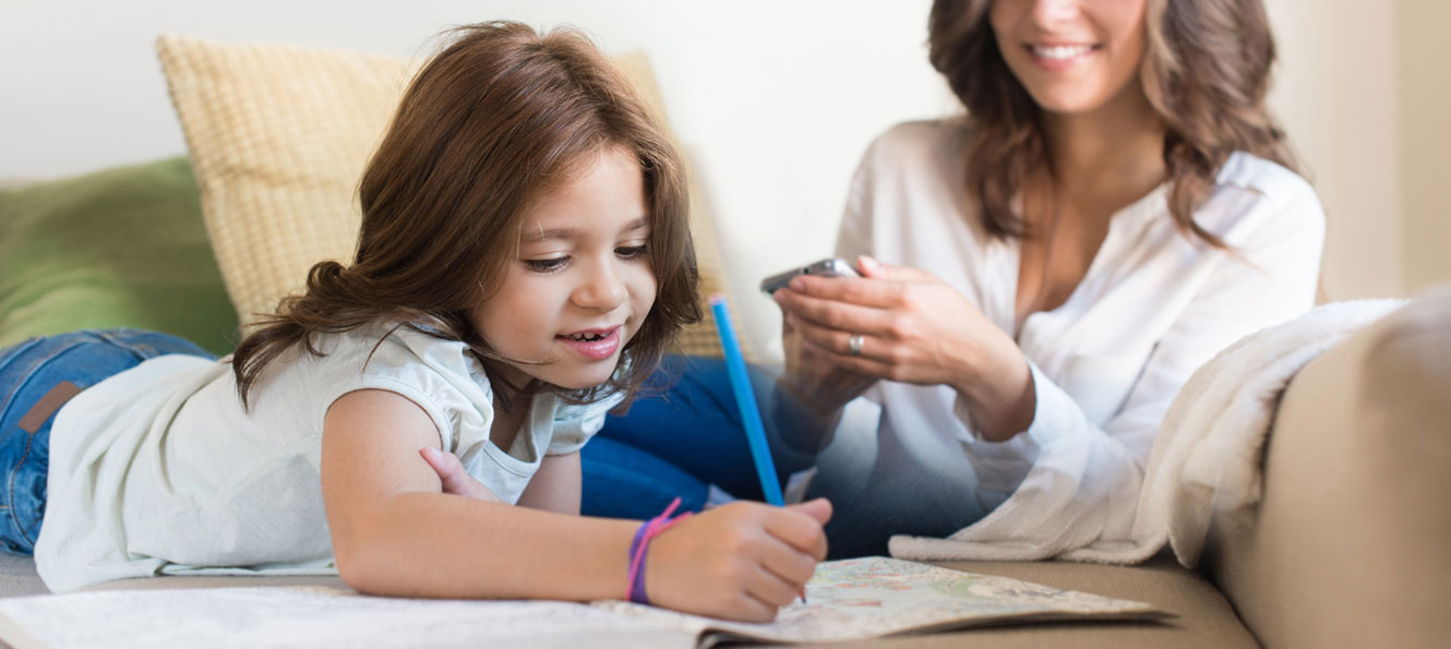 banking on mobile at home, with a small child coloring nearby