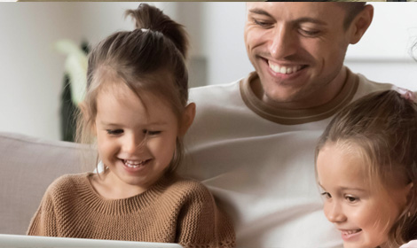 father and two children sitting together in the family living room