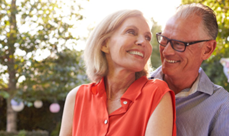 mature couple smiling at each other in an outdoor setting