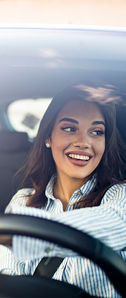 woman smiling inside car looking out of the window