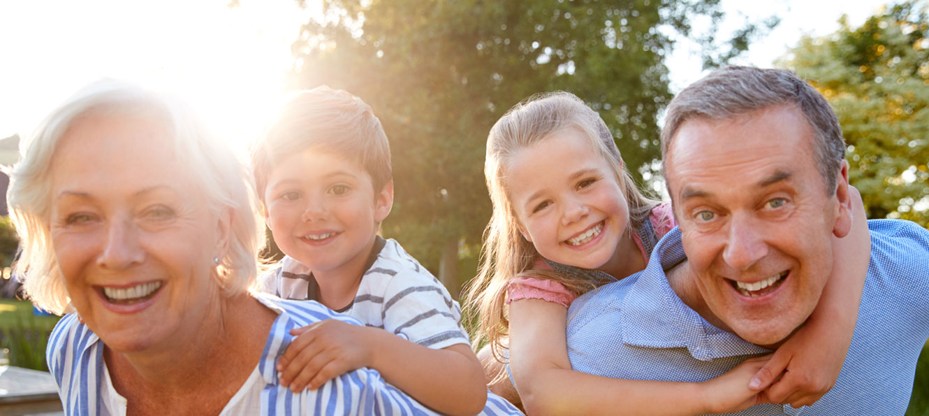 mature couple posing with two grandchildren