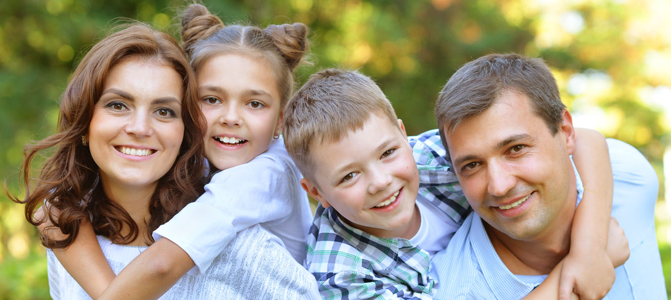 couple posing with their two children outdoors