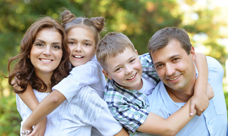 couple posing with their two children outdoors