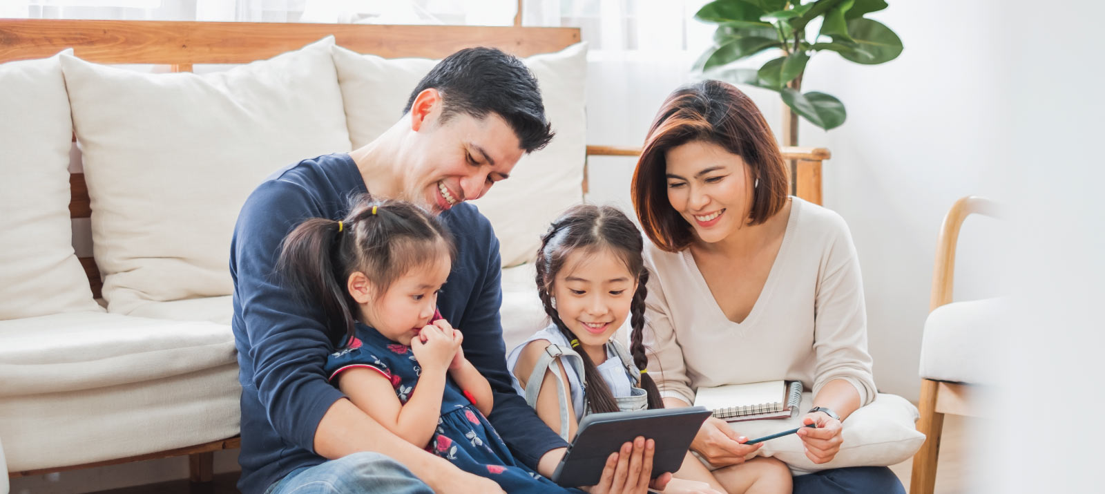 family sitting at home looking at tablet