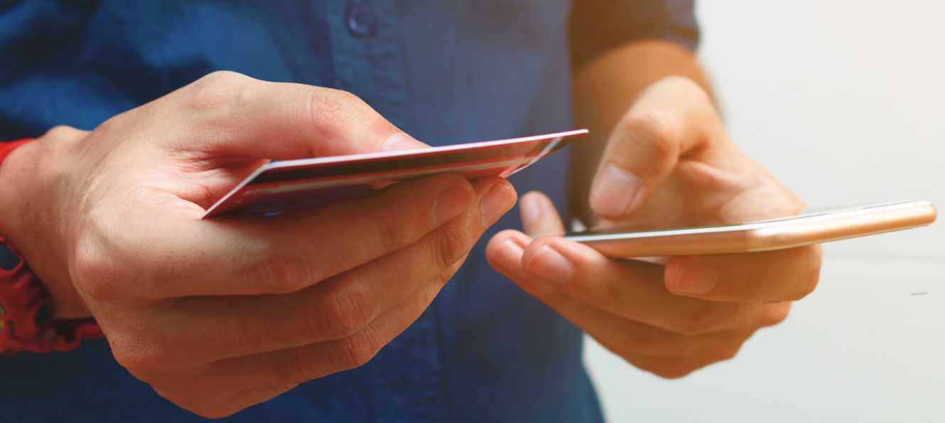 person using a debit card and smartphone