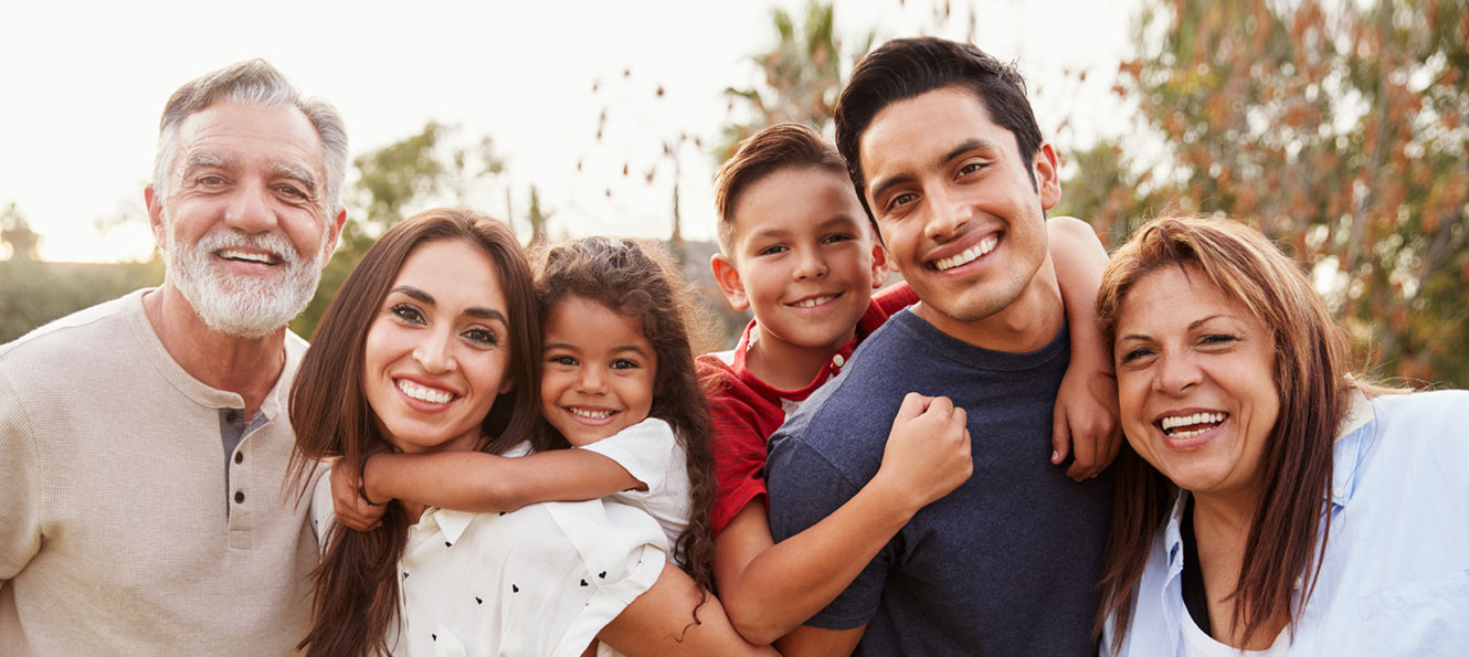 extended family portrait while gathered together and smiling outdoors