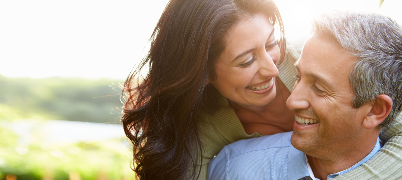 couple smiling at each other in an outdoor setting