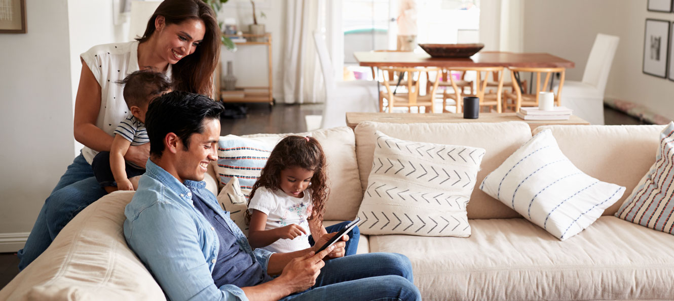 Family of four enjoying time together on their couch at home