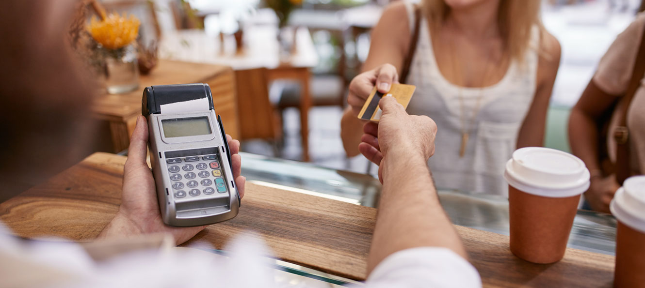 woman using a debit card to pay for coffee