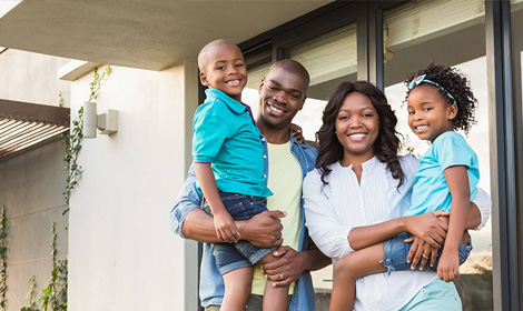 a family of four standing outside smiling at the viewer