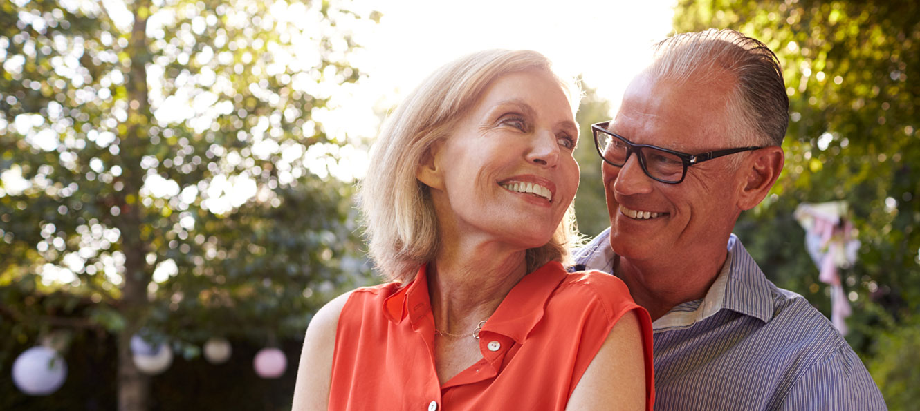 mature couple smiling at each other in an outdoor setting