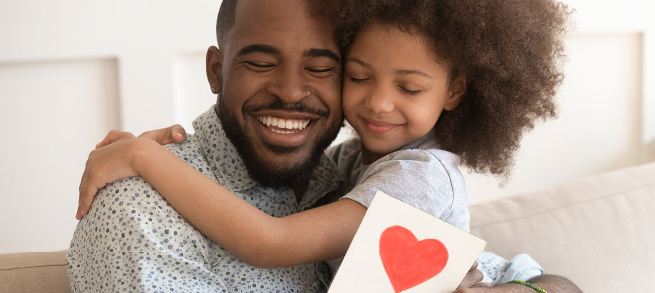 father and daughter sharing a hug and smiling