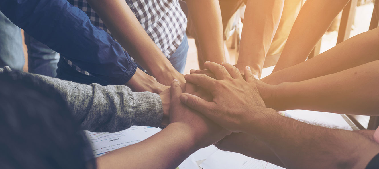 closeup of a group of hands gathered together in a circle