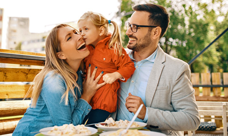 family of three smiling while enjoying the outdoors