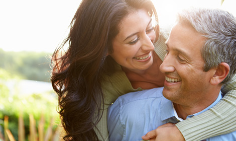 couple smiling at each other in an outdoor setting